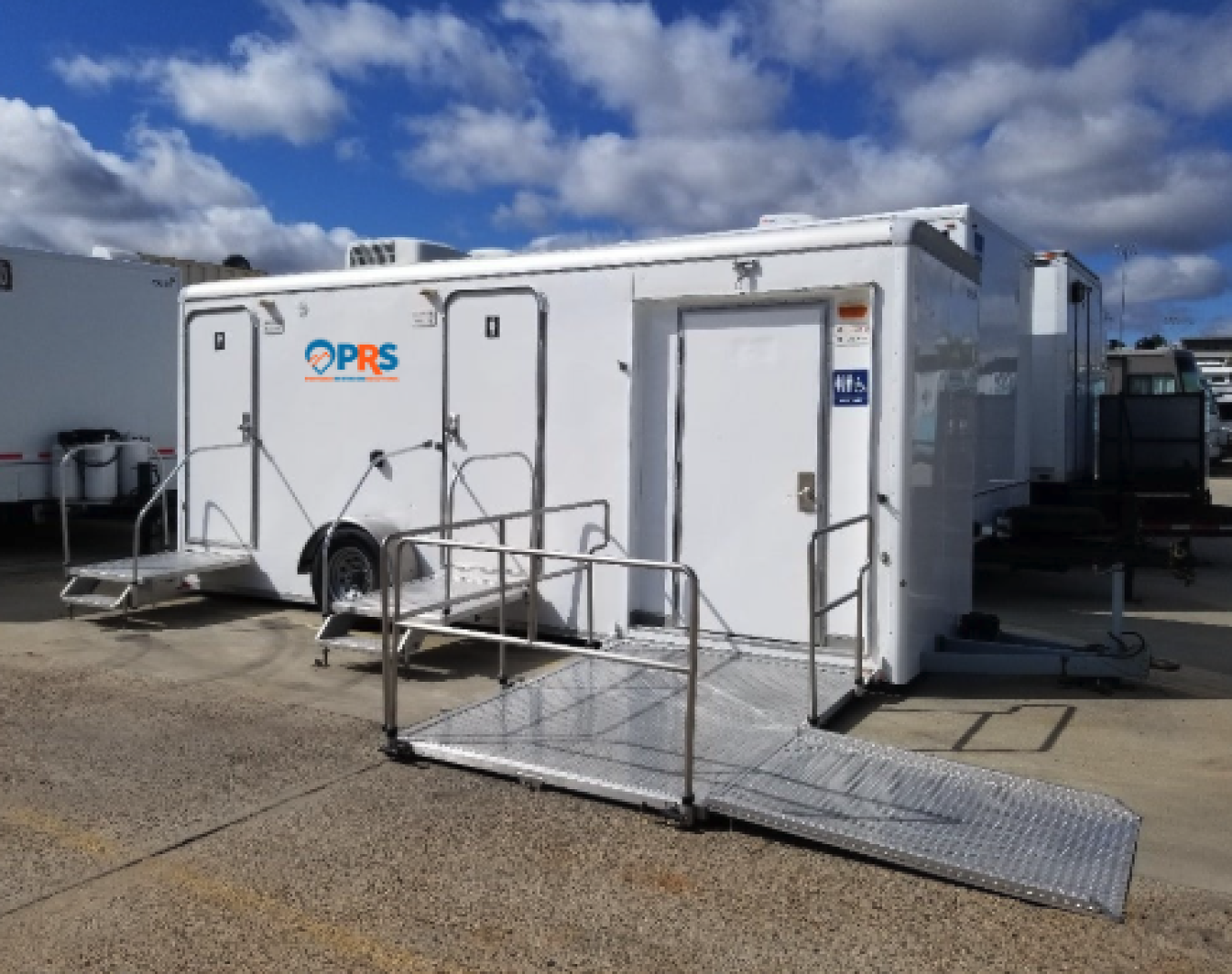 Crew finishing setup of a luxury unit for Restroom trailer rental in Longmont, CO at a vineyard event