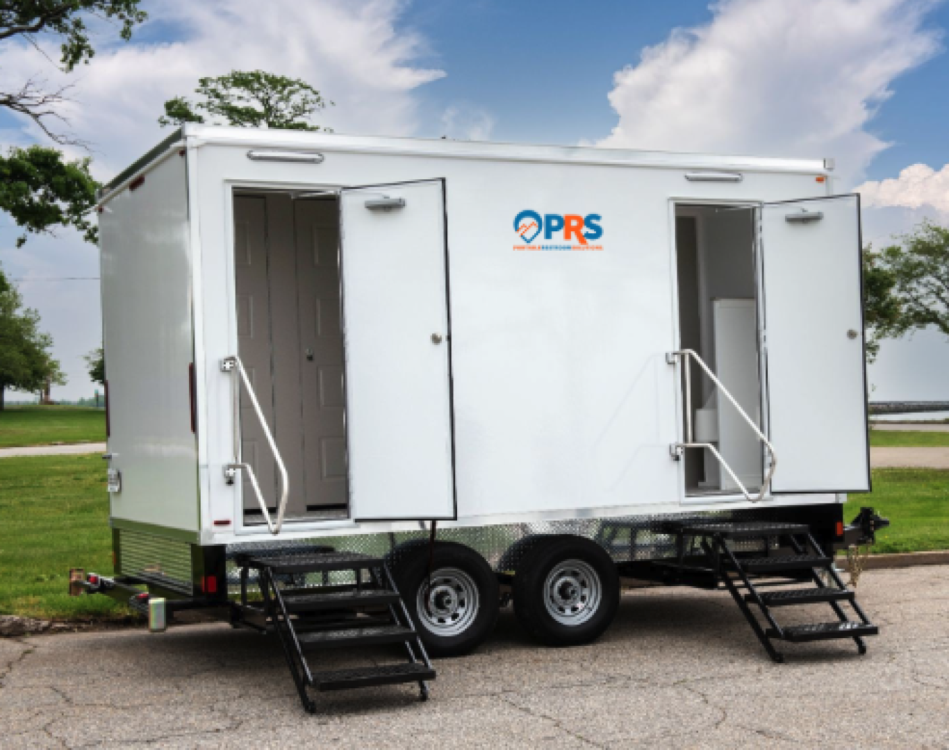 Evening event setup featuring a well-lit Restroom trailer rental near me outside a town center venue